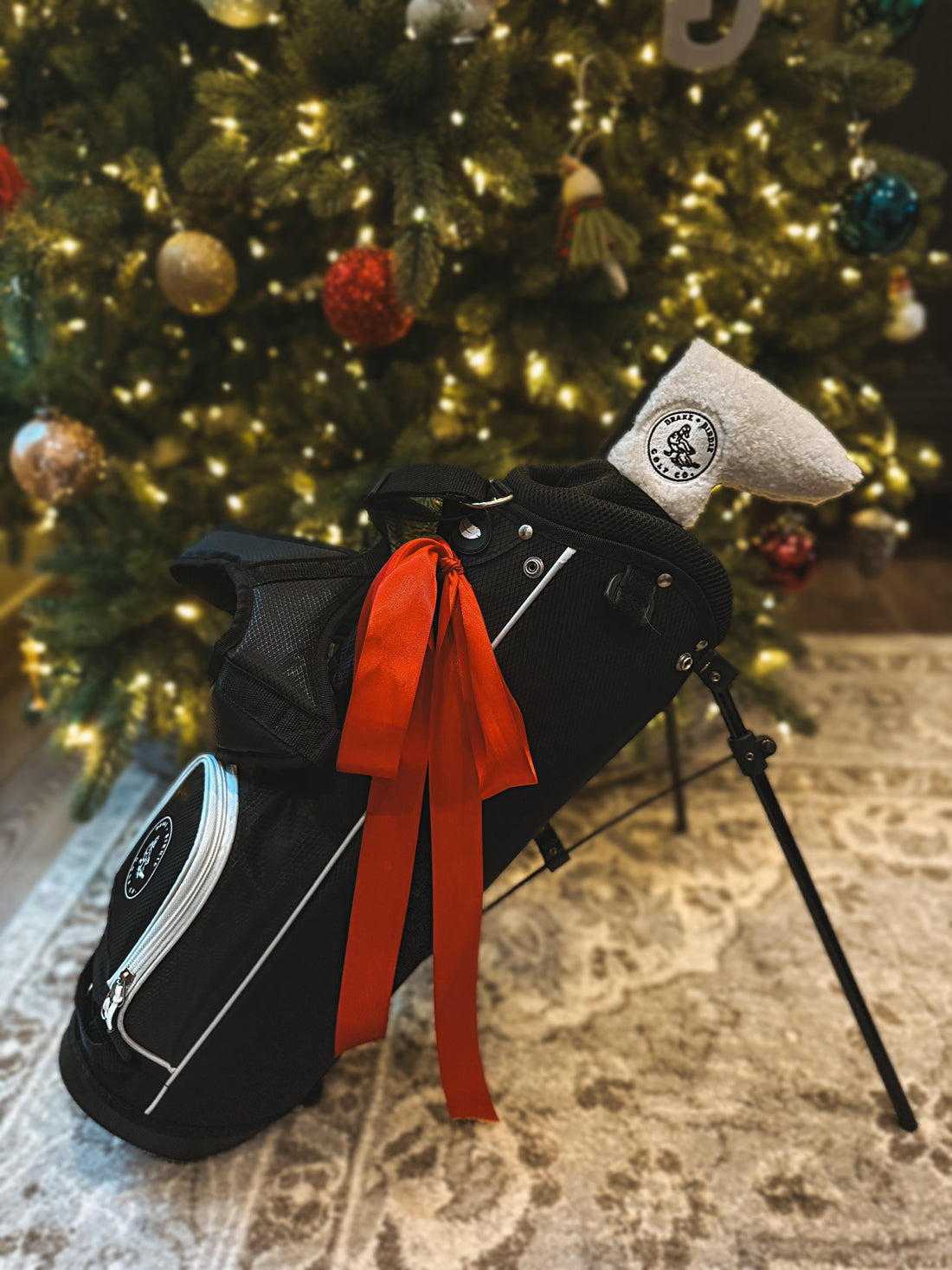Toddler golf gear arranged under a Christmas tree, golf gifts for kids ages 2 to 5