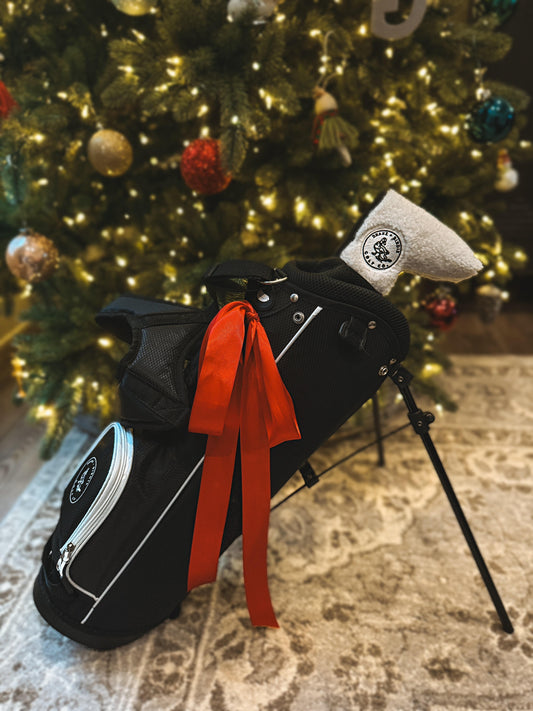 Toddler golf gear arranged under a Christmas tree, golf gifts for kids ages 2 to 5