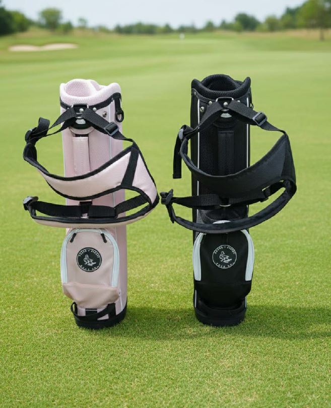 Two golf bags, one beige and one black, on a grassy field with trees in the background.