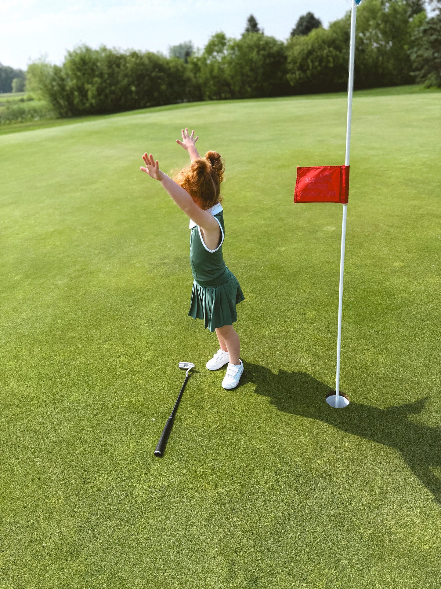 Toddler with putter on golf course