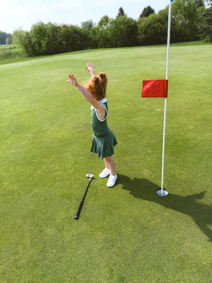 Toddler with putter on golf course