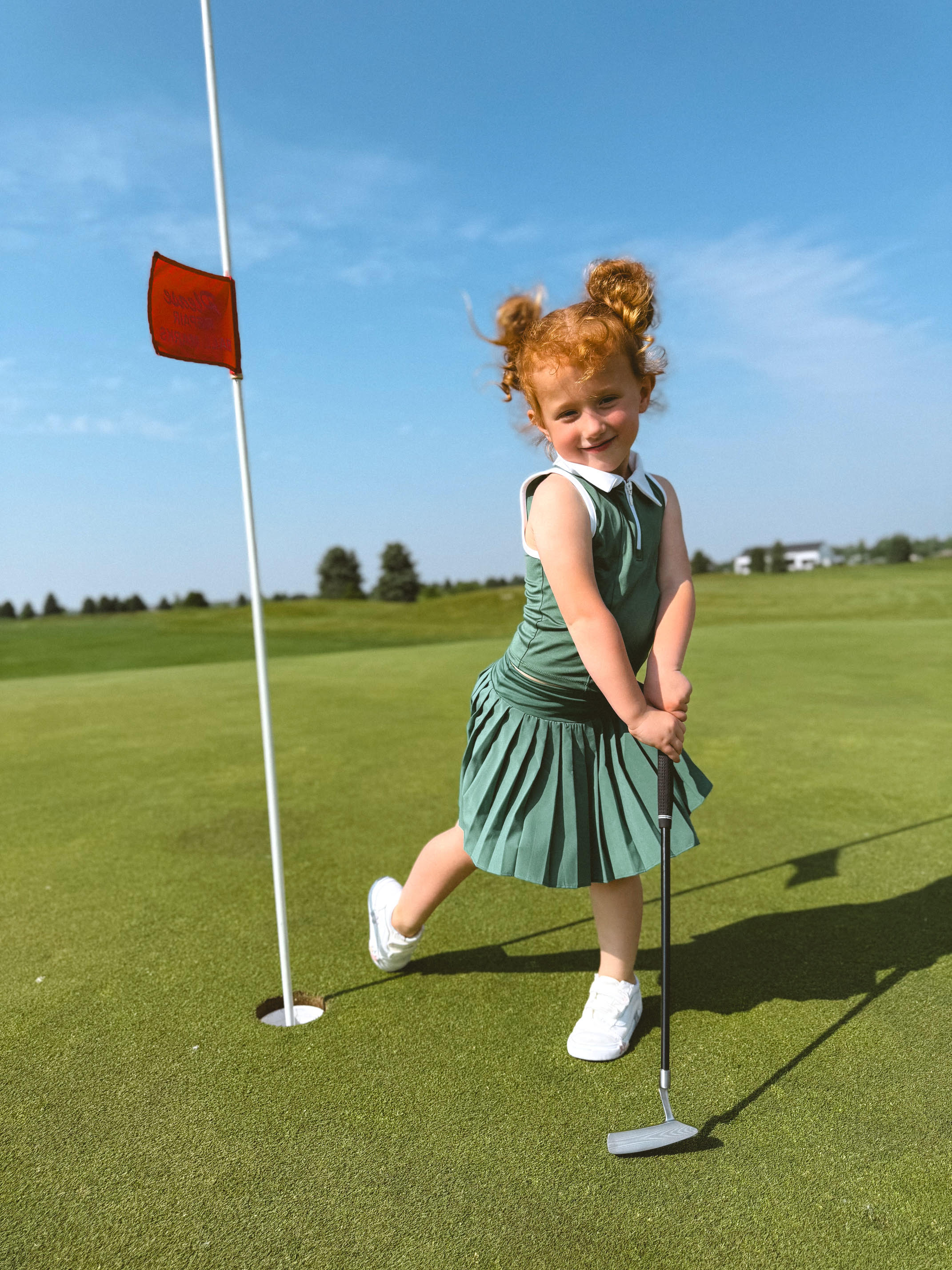 Child on golf course with a putter